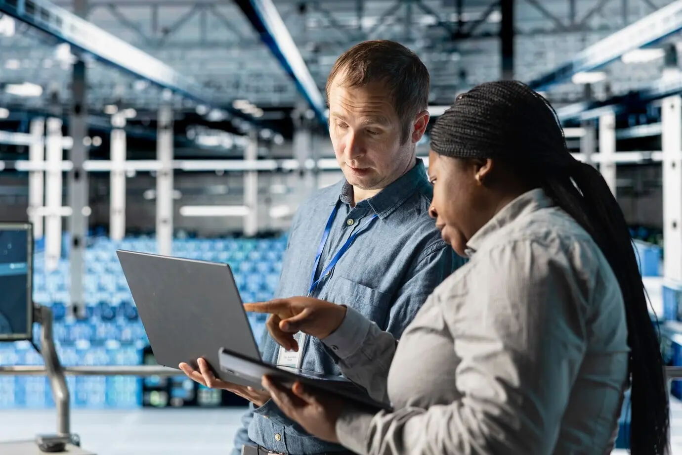 A group of data center administrators using a laptop to manage software updates.